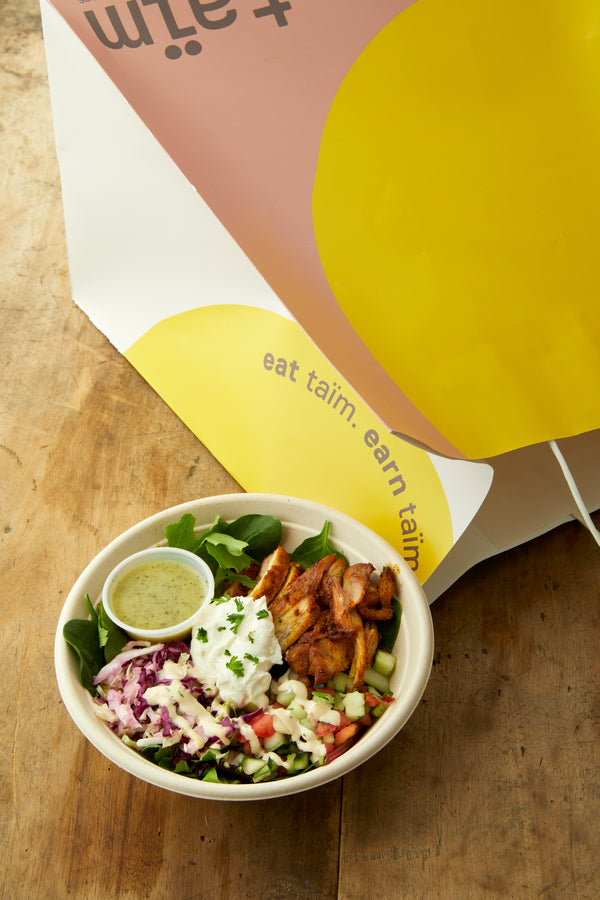 taim delivery bag with a chicken shawarma salad.  